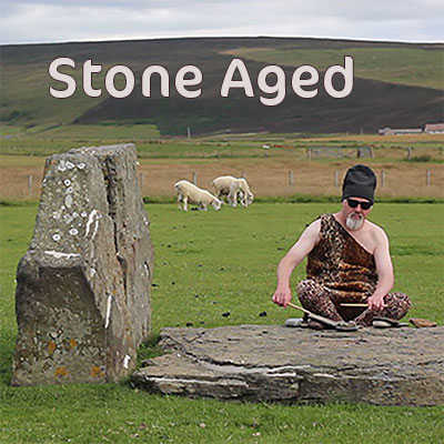 man playing a standing stone with drumsticks
